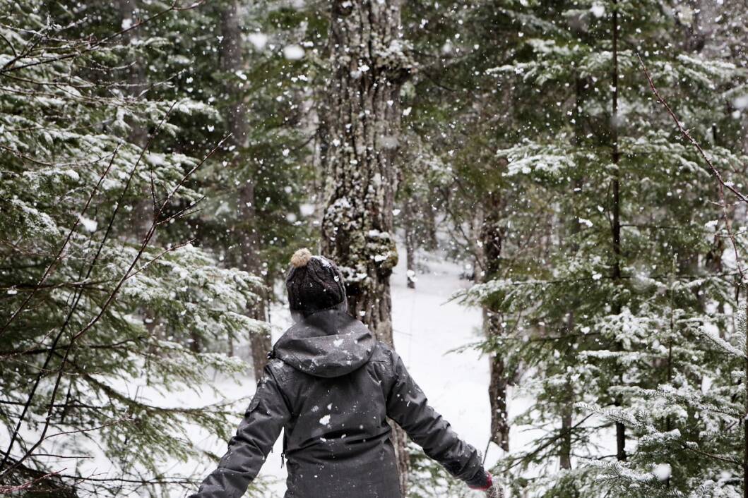 Djevojka sa zimskim kaputom raduje se snijegu
