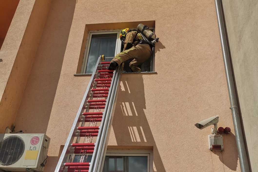 Vatrogasac ulazi u stan kroz prozor