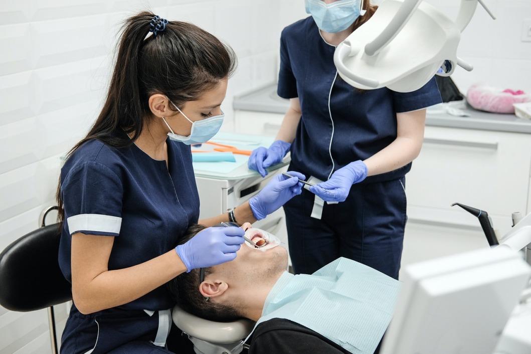 Stomatologinja popravlja zube pacijentu