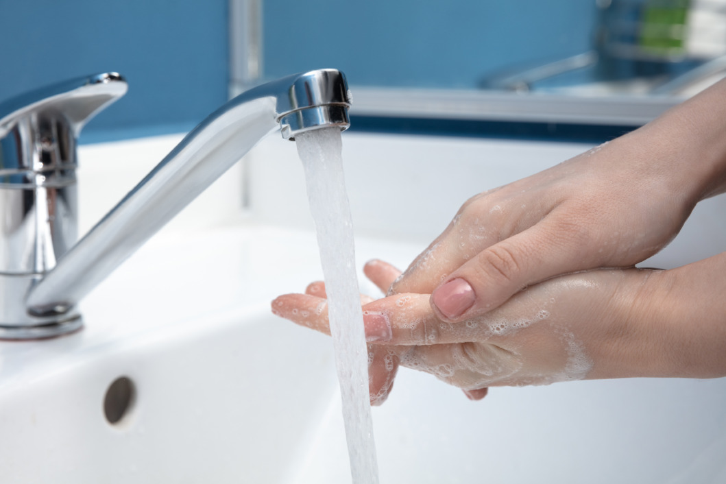 Žena pere ruke sapunom i vodom