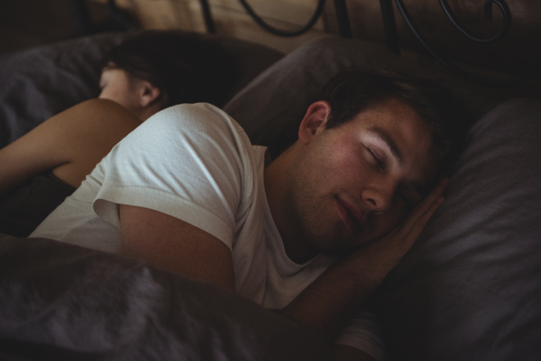 Žena i muškarac spavaju na krevetu dubokim snom