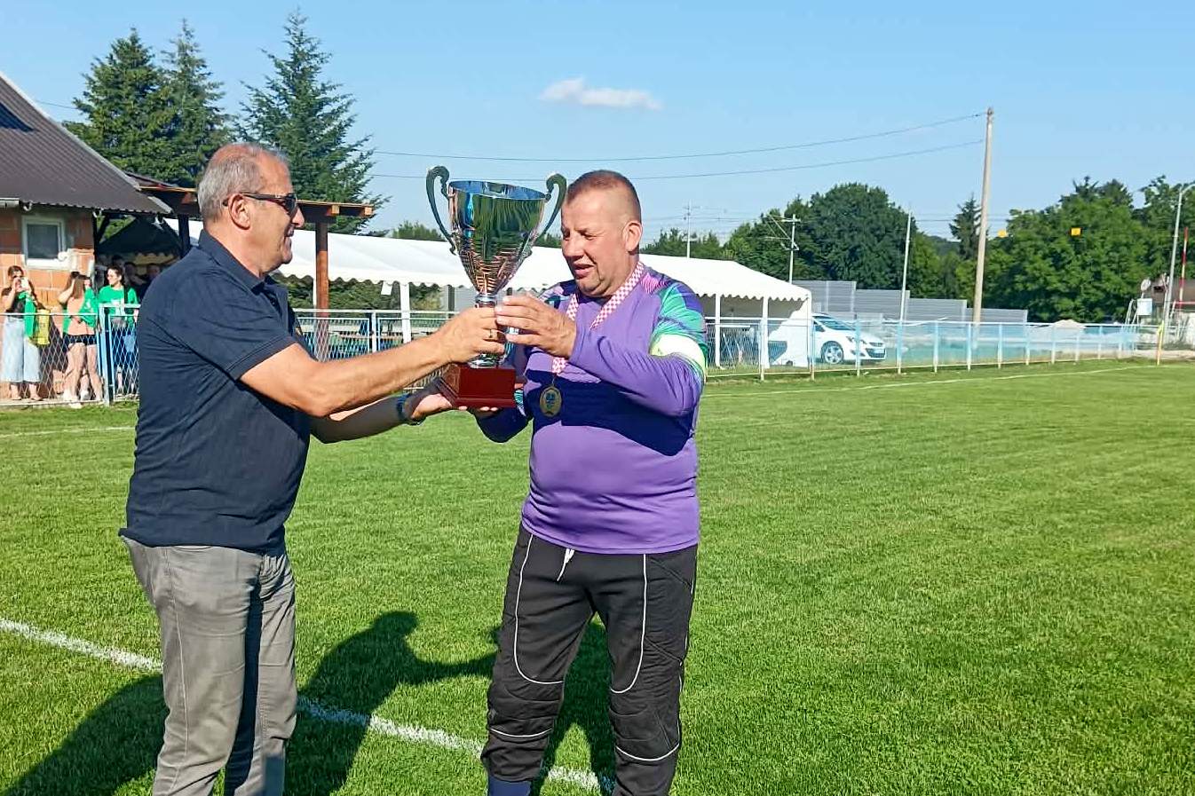 Branko Slatina uručuje pehar pobjednika Druge ŽNL kapetanu veterana Reke Davoru Dološčaku